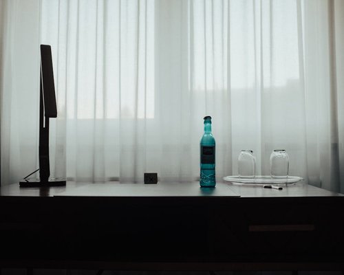 Un espacio de trabajo ordenado con una botella de agua y luz natural